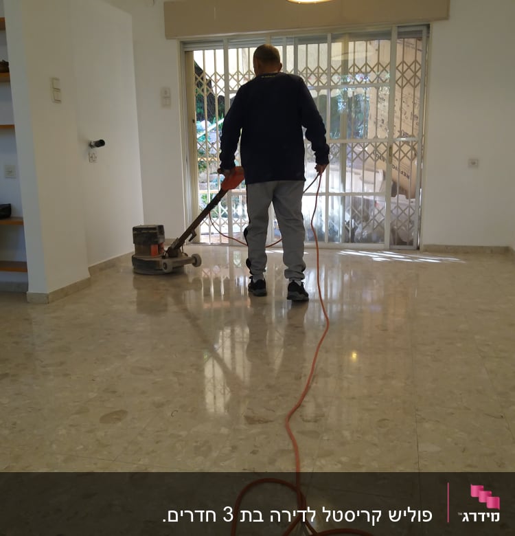 אדם מנקה רצפה עם מכונת פוליש חשמלית